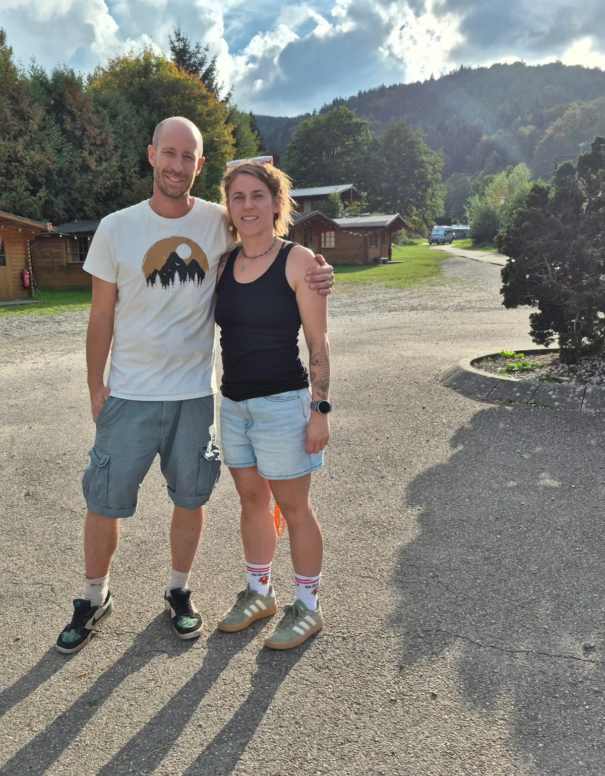 Anika and Patrick together in front of the wooden cabins at Albtal-Arena.